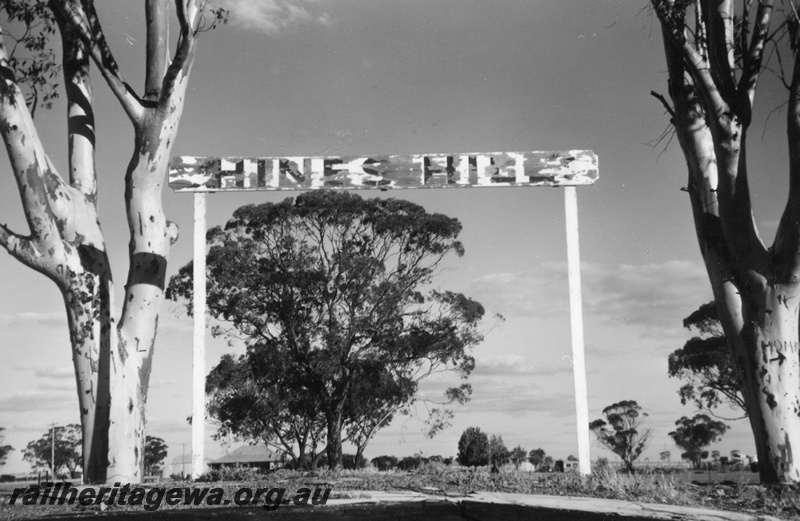 P22003
Station nameboard, flanked by trees, building, Hines Hill, EGR line
