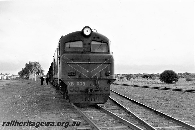 P22812
XB class 1008, on northbound No 191 goods, trackside buildings, 2 workers, siding, Kookynie, KL line, side and front view 
