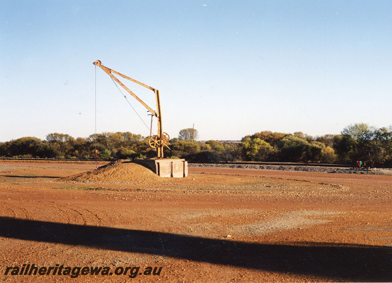 P22854
Platform crane mounted on an isolated  concrete block, point lever and point indicator in the background , location unknown.
