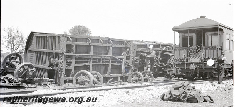 P22907
Rear end collision of No 66 Goods and AKRU 63 Goods at Frenches EM line on 22 October 1940 1 of 3, Z class 111 on side, wheels and axles on tracks, 2 onlookers, passenger carriage with end platform, trackside view
