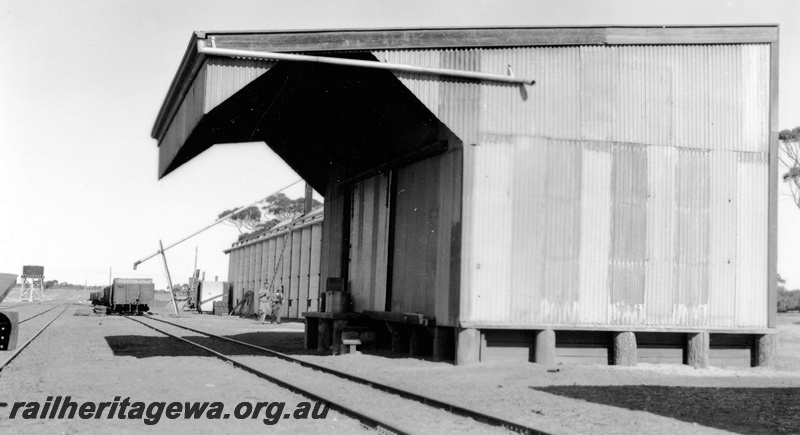P23114
Goods shed 4th class, wheat bin behind, water tower with a squatter tank in the background, Ongerup, TO line, side and end view from track level
