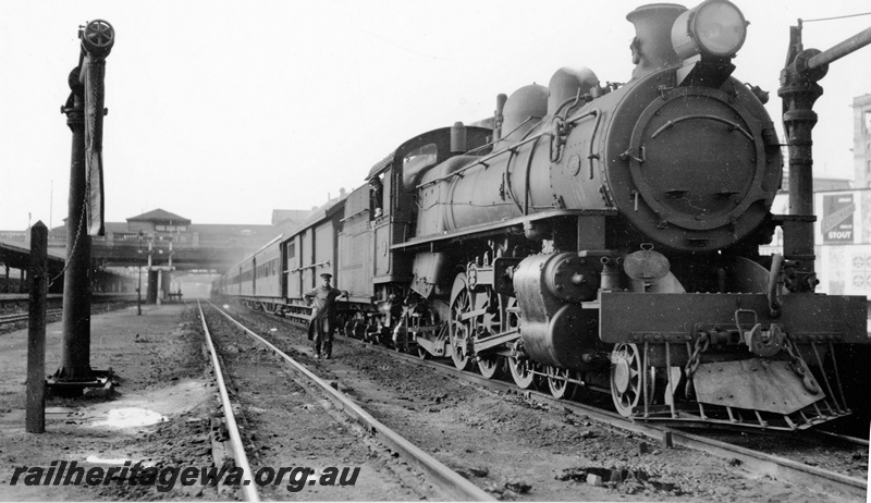 P23125
P class locomotive on the Kalgoorlie Express, water  columns, overhead bridge, crew, platform, canopy, city buildings, Perth station, ER line, side and front view from trackside 
