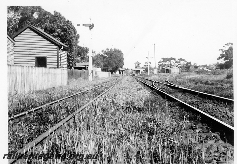 P23128
Station buildings, platforms, signals, goods shed, elevated signal box, siding, Guildford, ER line, distant view along the track looking west

