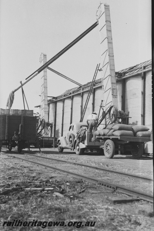 P23171
Grain loading, wagon, track, worker, elevator, wheat bin, view from track side
