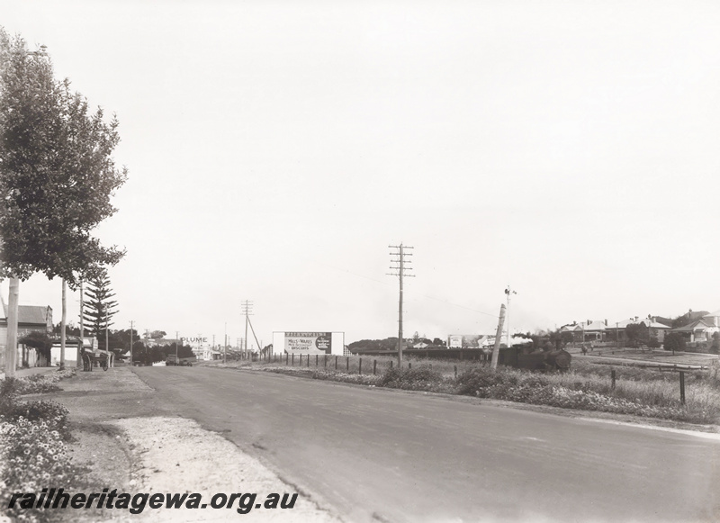 P23443
Steam hauled train, bill board for Mills and Wares biscuits, railway track, road, houses, Cottesloe, ER line, road level view
