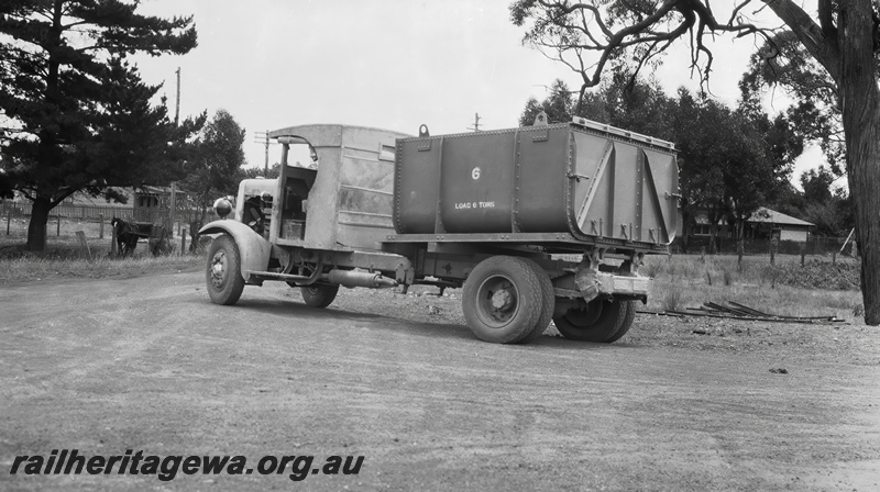 P23515
Truck with bin to be  loaded with cement for the construction of Canning Dam, on dirt road between trees, Armadale, SWR line, road level view, developed 19341200. See also P23513 & P23514.
