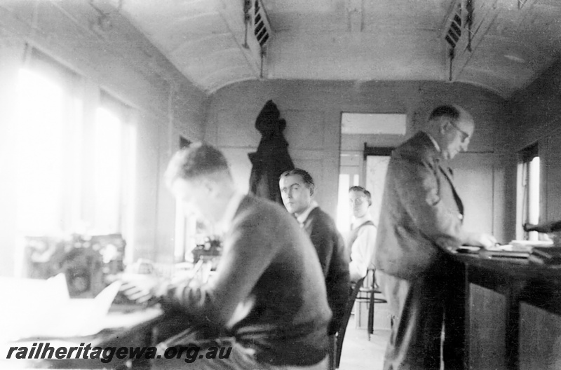 P23518
Inside the Orderly Room carriage(Office car) with clerks Keith Morrell (nearest to camera) and Dick Wallace. On the right is Mr. Johnson who was the Manpower Officer. At the rear is H. (Bert) McCarthy.
