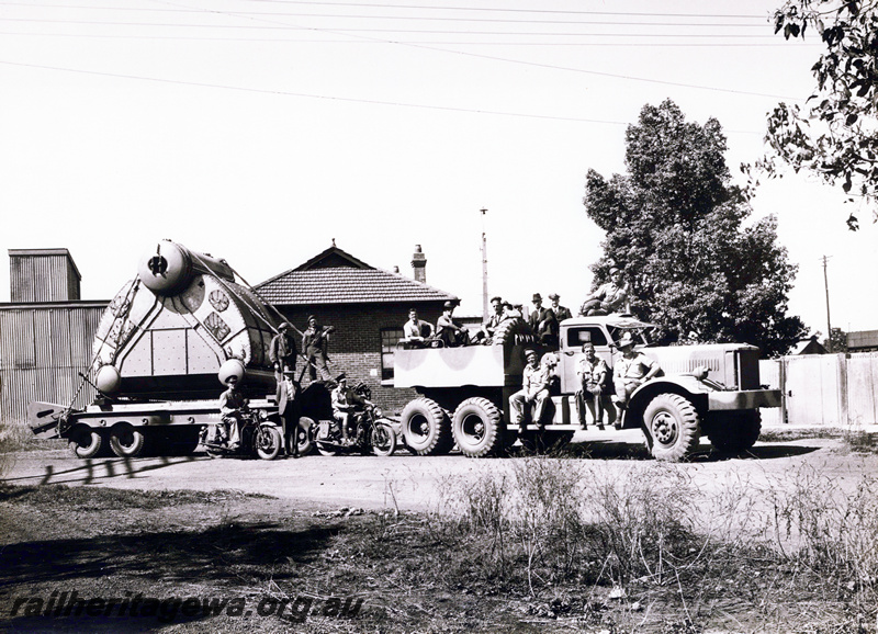 P23530
The first Yarrow class boiler leaving the Midland Workshops by AIF truck for Fremantle. for HMAS Corvettes, side view of the truck, trailer and boiler with men on  the truck
