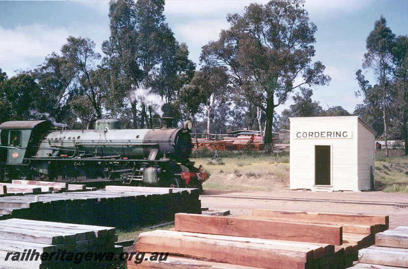 P23562
W class 936, Out of Shed with nameboard above the door, stacks of sleepers in the foreground,  Cordering, timber mill in background .overall view of the site, WB line.
