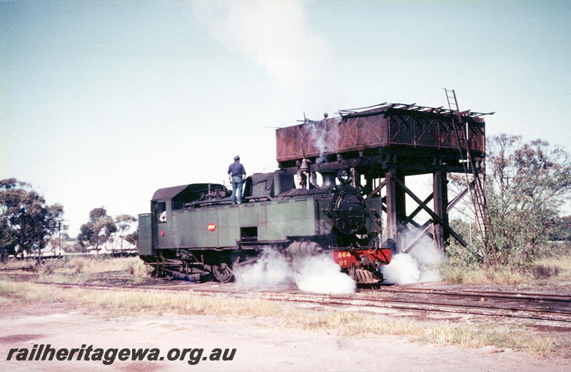 P23571
UT class 664, water tower with a MRWA style cast iron 10,000 gallon tank, Watheroo.  MR line. Loco taking water
