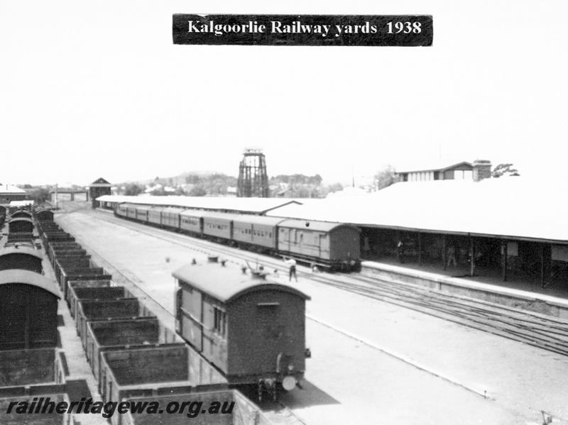 P23635
Railway yards, passenger carriages, vans, wagons, tracks, worker, platform, canopy, water tank, Kalgoorlie, EGR line, elevated view
