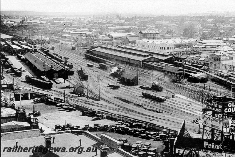 P23769
Perth Goods Yard, elevated view looking west, Shows the goods sheds, A cabin signal box, carriage sheds and water tower with advertisements
