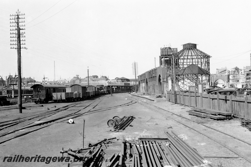 P23773
Goods rolling stock in Perth Goods Yard, water tower, partially demolished Perth Markets, view along the yard looking east, Boans store in the right hand side background
