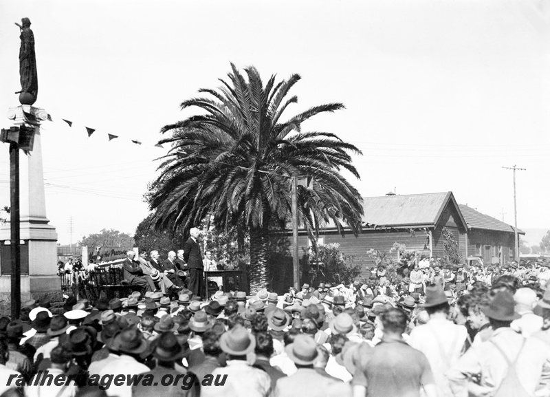 P23807
Ceremony on the handover of ASG class loco to the Commonwealth Land Transport Board, speaker and other dignitaries on dais, crowd of workers, Midland Workshops, ER line, view from ground level
