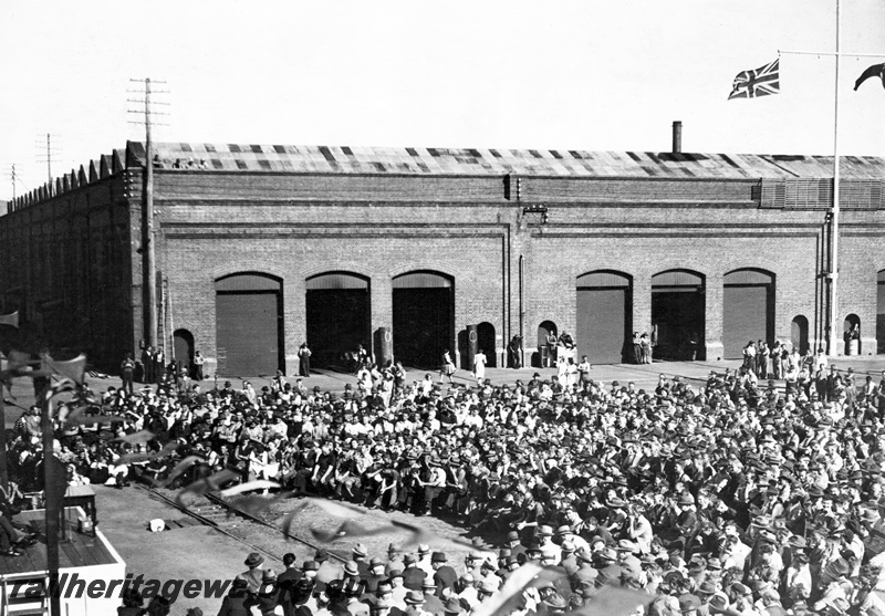 P23808
Ceremony on the handover of ASG class loco to the Commonwealth Land Transport Board, speaker and other dignitaries on dais, large crowd of workers, workshop buildings, Midland Workshops, ER line, elevated overview
