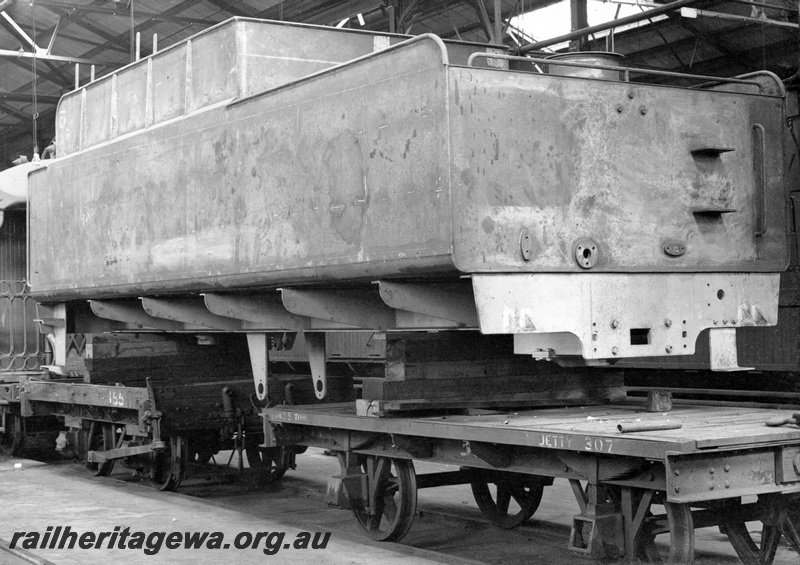 P23860
S class loco tender, ready for painting, supported on wooden blocks over two four wheel wagons 155 and JETTY 307, Midland workshops, Midland, ER line, side and rear view
