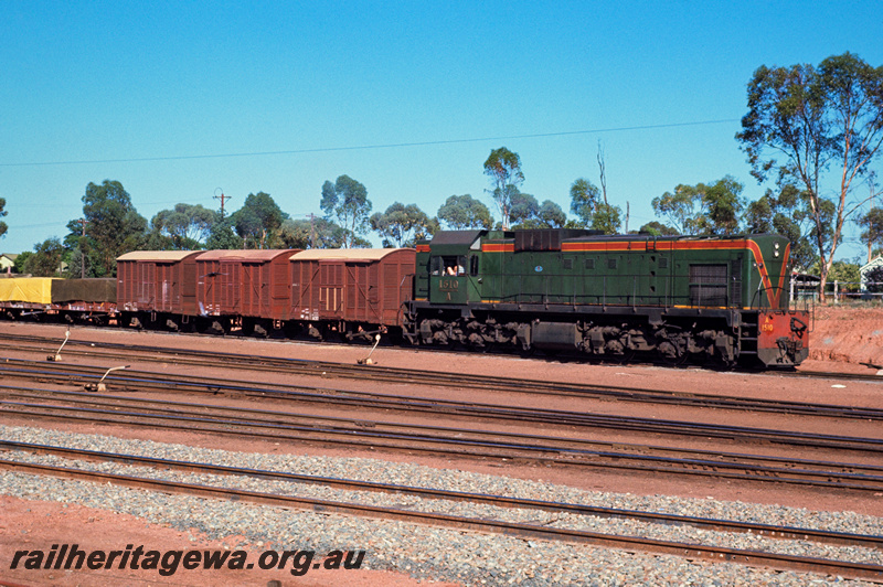 P23880
A class 1510, on goods train of vans and covered wagons, point levers, Kalgoorlie, EGR line, side and end view from track level 

