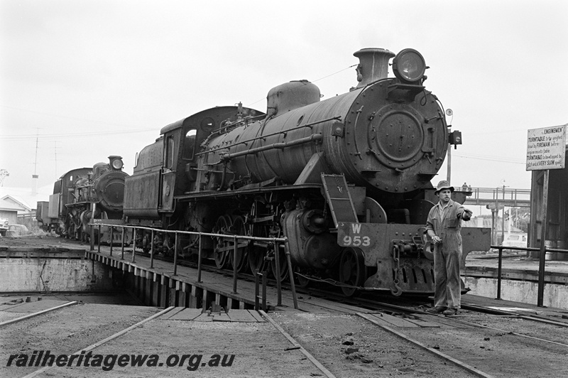P23889
W class 953 on turntable, PMR class behind, worker on turntable  bridge, loco depot, pedestrians on overhear footbridge, Bunbury, SWR line, side and front view
