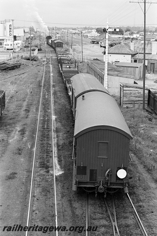 P23898
PMR class 729, on goods train, level crossing, signals, Ampol tanks, trackside buildings, view from rear of train from elevated position
