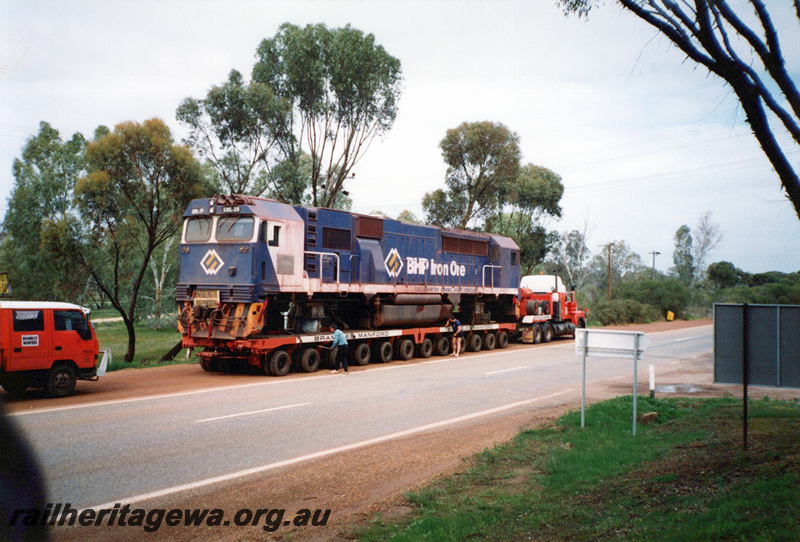P23931
BHP Iron Ore GML class 20 loco in the blue with white stripe livery being transported by road, New Norcia, front and side view. Loco later renumbered to GML class 10

