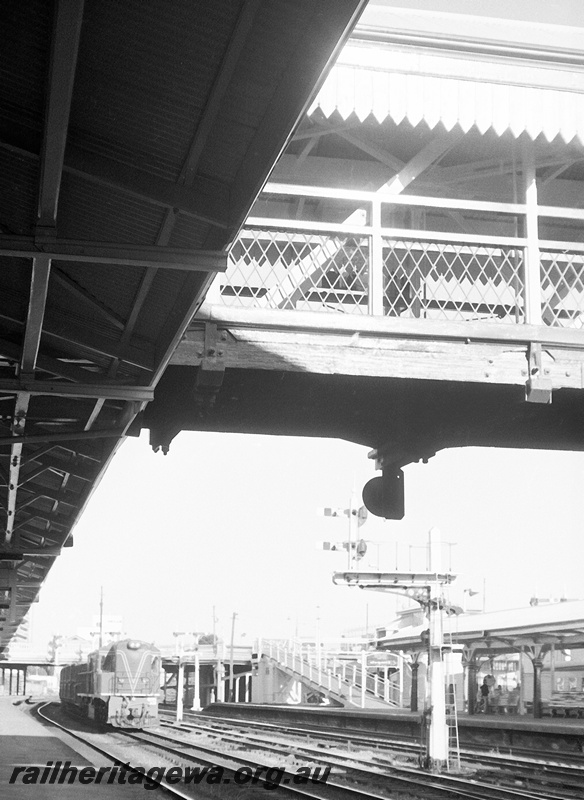 P23950
RA class 1918 on goods train, bracket signals, platform, canopy, overhead footbridge (part), ramp, Perth station, ER line, side and front view from platform
