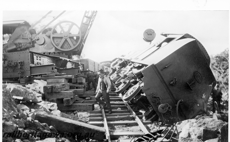 P23987
Derailment of No 42 Mixed at Cape Horn M line on 19271025, 2 of 2, DS class 387 off tracks, on side, mobile crane, wooden supports, workers, trackside view. See also P01669, P01800, P018801, P07273-278, P 21988, P23987  

