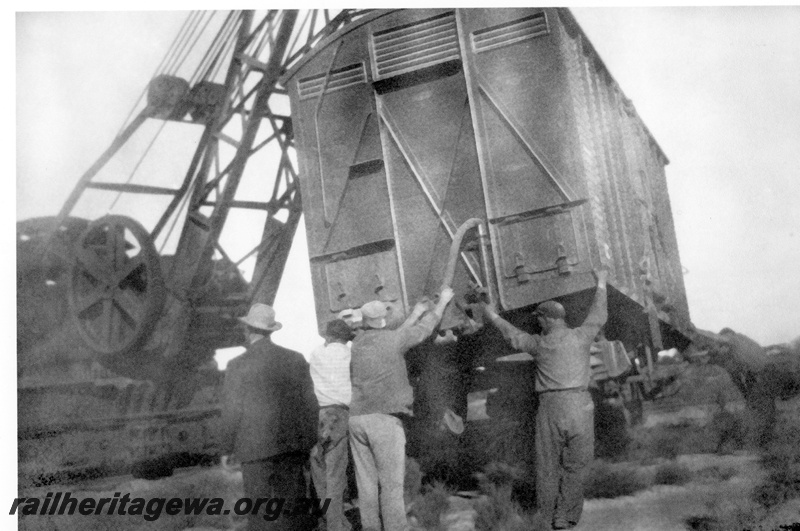 P23990
Derailment of No 60 Fast Goods near Nalkain WLB line, 3 of 7, DC class 22450 van being lifted by crane, workers, end and side view
