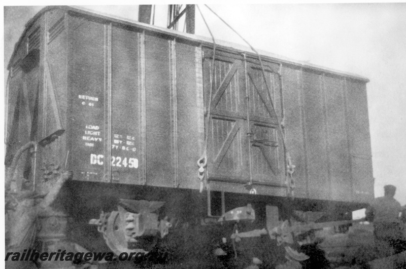 P23991
Derailment of No 60 Fast Goods near Nalkain WLB line, 4 of 7, DC class 22450 van being lifted by crane, workers, end and side view
