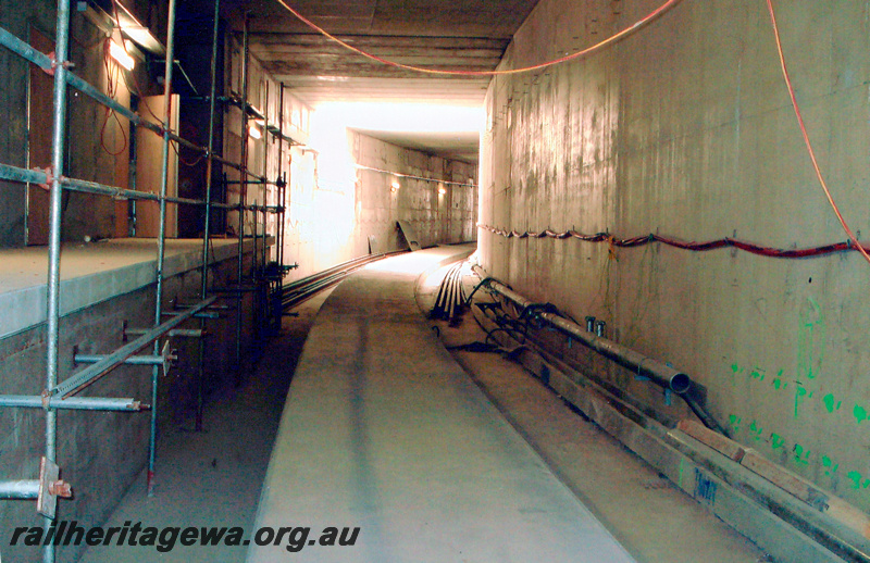 P24049
Raised concrete track bed with rails alongside, scaffolding, wiring, west of new Esplanade station, Mandurah line, view inside tunnel
