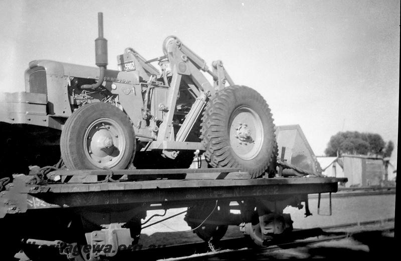 P24053
Chamberlain tractor NF 22352, on flat wagon, trackside buildings, side view from trackside 
