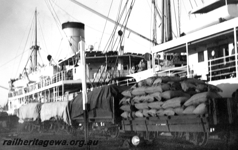 P24071
Carnarvon Jetty. Wagons loaded with sacks of whale meal being loaded onto ship.

