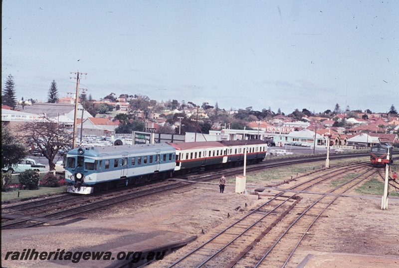 T04562
ADX class 670, Nanking blue and light grey livery, white tail disc, stainless steel cowcatcher, at the rear of a three car set on a  Fremantle bound suburban service departing  Claremont Station. ER line, view along the train,  ADX 670 ran in this livery from 7.7.1966 to 22.10.1968
