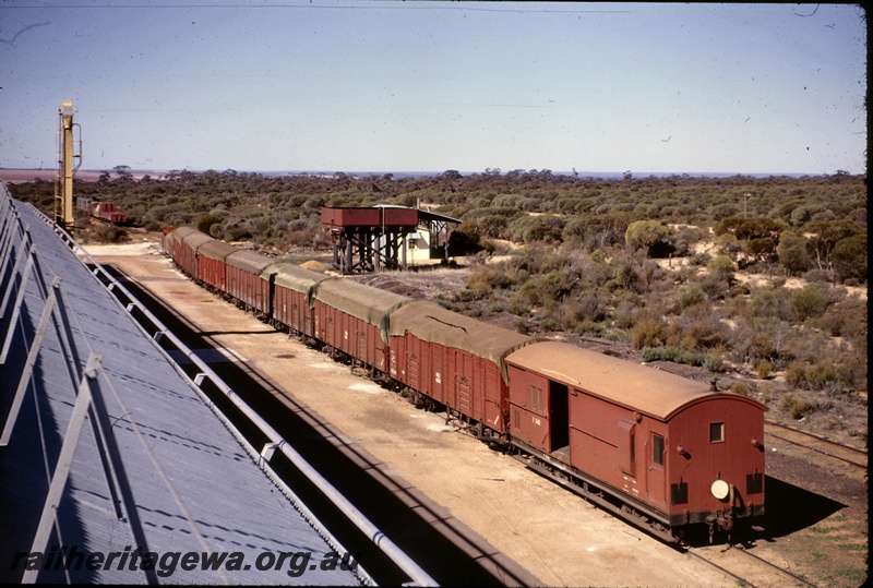 T04935
Z class 542, rake of tarpaulined covered bogie  wagons, wheat bin, water tower, 13,000 gallon cast iron water tank, siding, shed, Bonnie Rock, KBR line, elevated overview of the yard.
