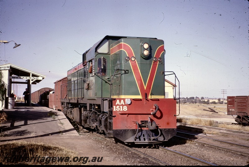 T04941
AA class 1518 on goods train, platform, station building, nameboard, man on station, Meckering, EGR line, view along the train down the platform.
