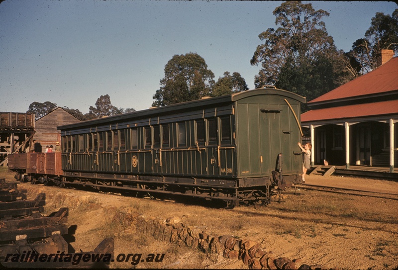 T05074
AA class 206 first class carriage in the plain green livery, side and end view, open wagons, on ARHS tour train, water tower with a wooden tank, children, wooden building, station building, Jarrahdale.
