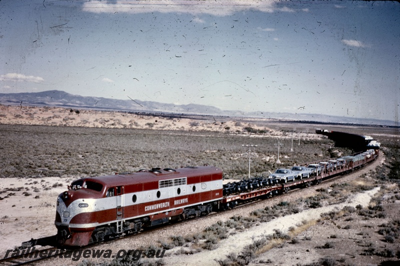 T05215
Commonwealth Railways (CR) GM class 19 in maroon and silver livery, on freight train, TAR line, front and side view
