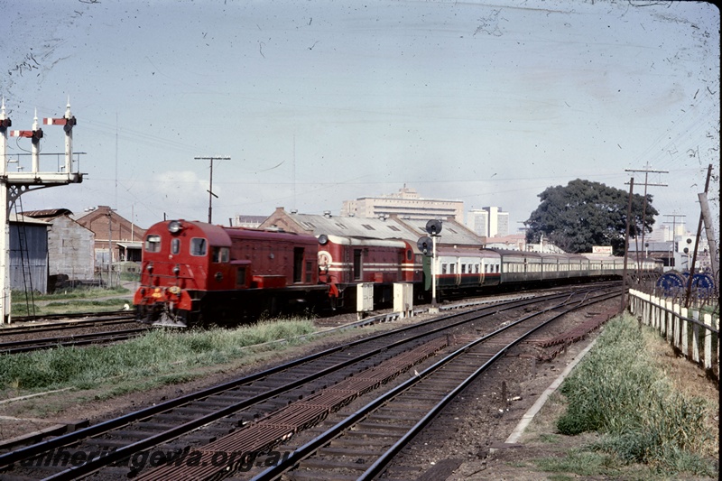 T05251
Ex MRWA F class 45 in red livery, double heading with  F class 43 in the MRWA livery, coupled nose to nose, heading ARHS tour train to Boddington,  semaphore signals, colour light signals, point rodding, East Perth, ER line, view along the track towards Perht Station, Royal Perth Hospital in the background
