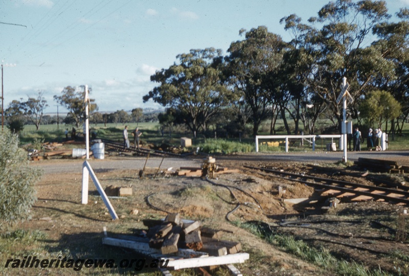T05464
Aftermath of smash at level crossing, onlookers, workers, debris, no rail or road vehicles in picture, ground level view 
