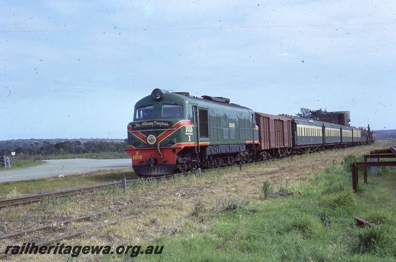 T05485
X class 1015 green and yellow livery hauling the Albany Progress at Elleker. Headboard on locomotive. GSR line.
