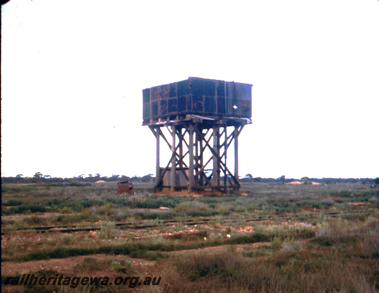 T05687
Water tower with a 25,000 gallon cast iron tank once painted black, small shed next to the tower, end and trackside view, Broad Arrow, KL line
