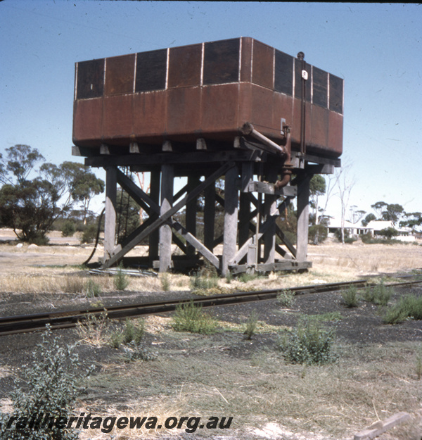 T05688
Water tower with a 25,000 gallon cast iron tank, some panels on the tank painted black, outlet pipe attached to the tank, end and trackside view, Pingaring, LH line 
