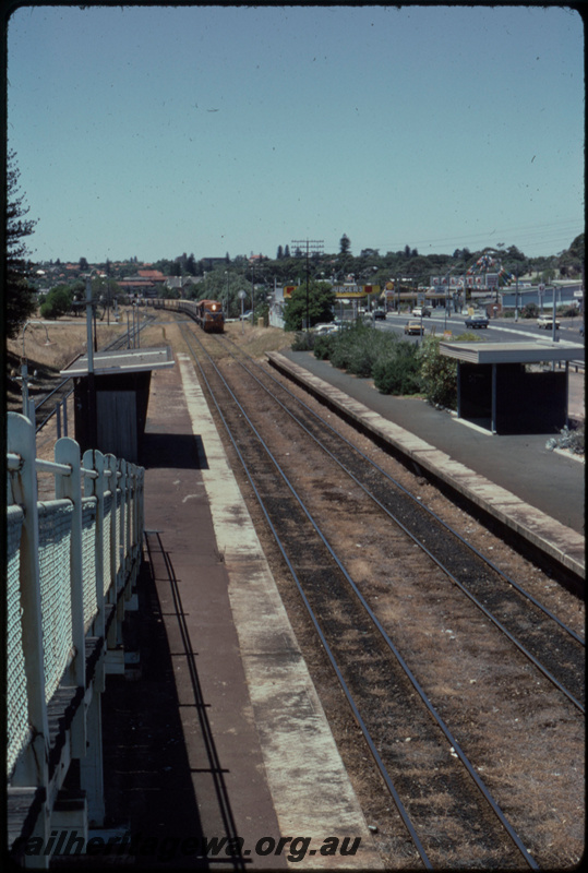 T07699
DA Class 1577, DB Class 1588, Up loaded grain train, XG Class coal wagons used in grain traffic, Mosman Park, bi-directional freight line between Cottesloe and Leighton on far left, footbridge, station shelters, platform, ER line

