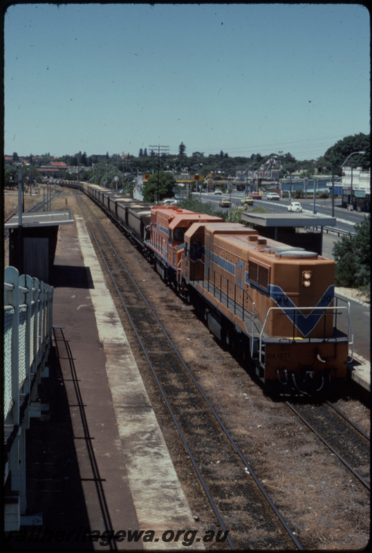 T07700
DA Class 1577, DB Class 1588, Up loaded grain train, XG Class coal wagons used in grain traffic, Mosman Park, bi-directional freight line between Cottesloe and Leighton on far left, footbridge, station shelters, platform, ER line
