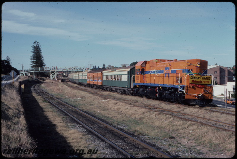 T07702
A Class 1513, Up passenger special, The Sunday Times Watsonia Flyer, headboard, streamers on front of locomotive, first passenger train over the Fremantle Line since March 1981, Mosman Park, footbridge, bi-directional freightline between Cottesloe and Leighton in foreground, ER line
