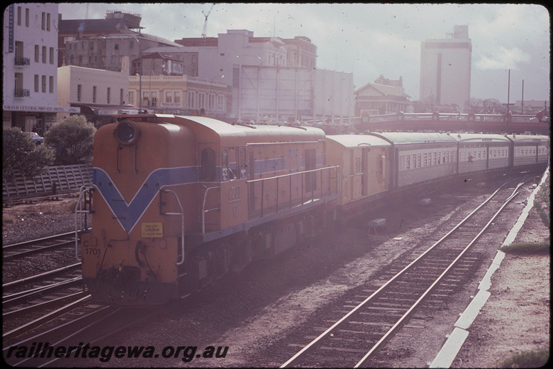 T08252
C Class 1701, Down suburban passenger service, departing City Station, Z Class brakevan, ARM Class sleeping carriage on hire from Hotham Valley, AYC Class Australind carriages, coaching set used temporarily to release ADL/ADC Class railcars for modification for two man working, stopping pattern sign says 